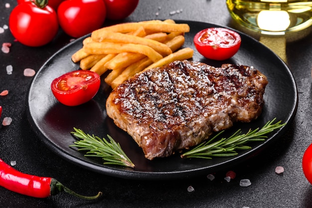 Chuletón de ternera con patatas, cebolla y tomates cherry. Jugoso bistec con mantequilla aromatizada