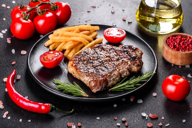 Chuletón de ternera con patatas, cebolla y tomates cherry. Jugoso bistec con mantequilla aromatizada