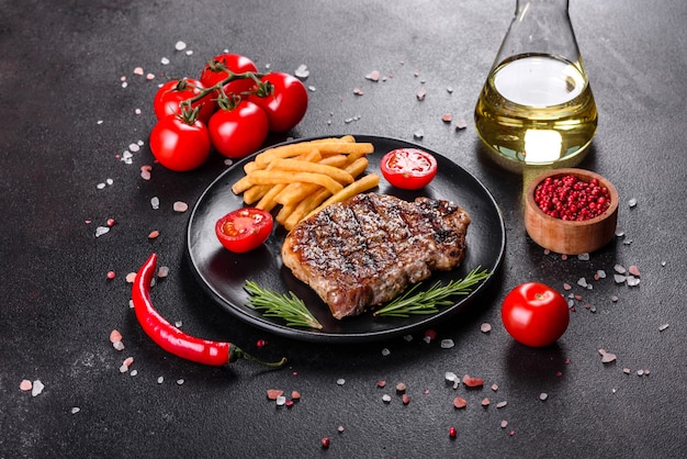 Chuletón de ternera con patatas, cebolla y tomates cherry. Jugoso bistec con mantequilla aromatizada