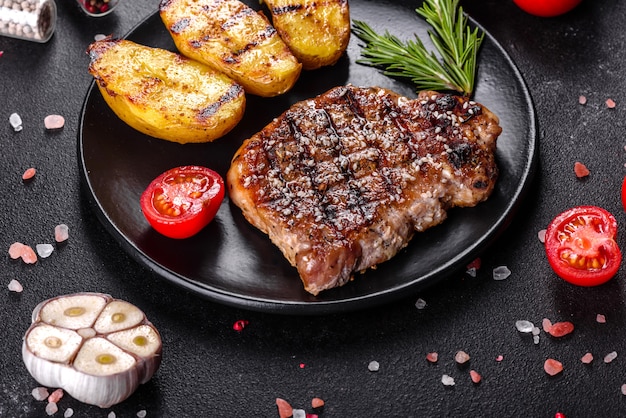 Chuletón de ternera con patatas, cebolla y tomates cherry. Jugoso bistec con mantequilla aromatizada