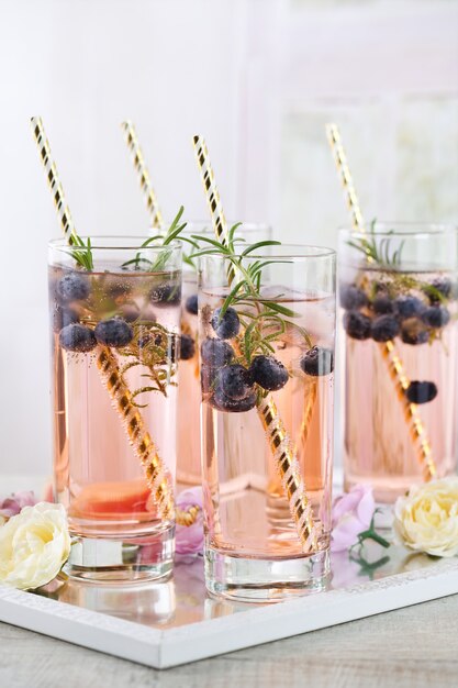 Chupito frío en vaso con arándanos, cubitos de hielo, romero. Inspiración festiva al estilo provenzal