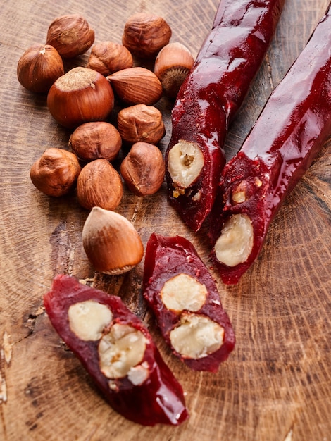 Churchkhela, composición de dulces caseros georgianos y nueces sobre fondo de madera