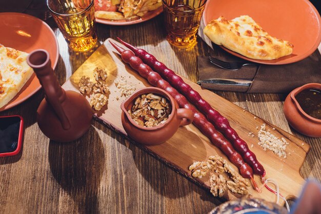 Foto churchkhela dulce georgiano tradicional hecho de jugo de uva y avellanas en una tabla de madera rústica