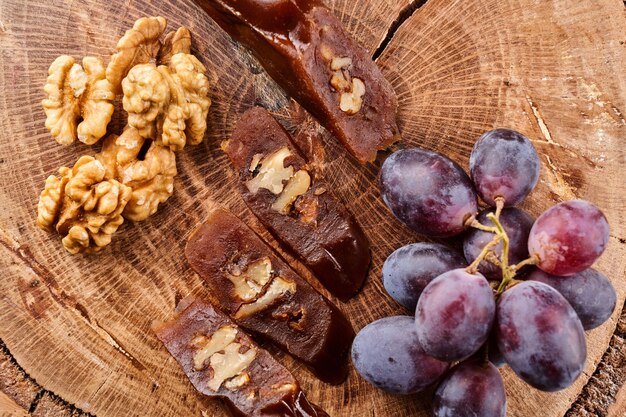 Churchkhela, nationales georgisches Dessert aus Traubensaft und Walnüssen, Komposition auf einem Holztisch