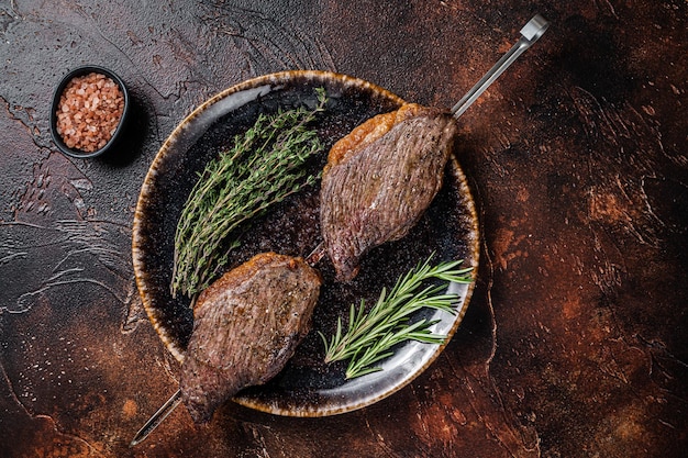 Churrasco brasileiro grelhado bife de picanha seco envelhecido com ervas Fundo escuro Vista superior