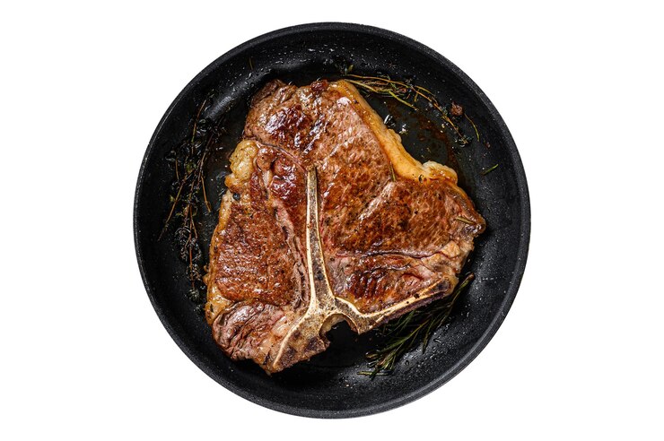 Foto churrasco carne de vaca grelhada com ossos bife com ervas em um prato isolado em fundo branco