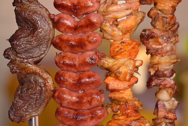 Foto churrasco carne salsicha em espetos de frango e bacon típico da gastronomia popular brasileira