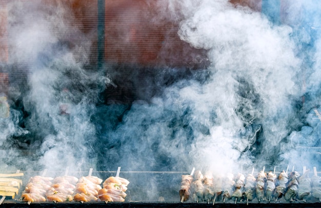 Churrasco, churrasqueira fumaça e fogo, carnes grelhadas. Fumaça pesada sobre carne grelhada