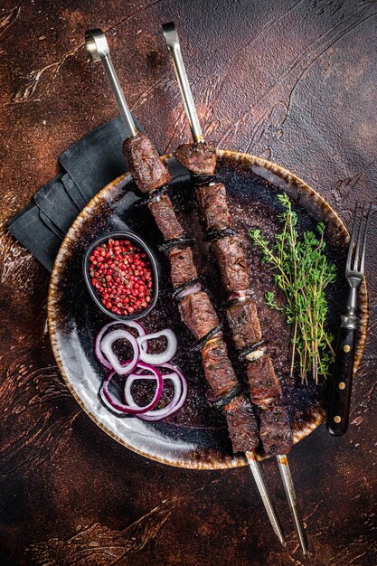 Churrasco de carne de cordeiro Shish kebab com cebola e especiarias Fundo escuro Vista superior