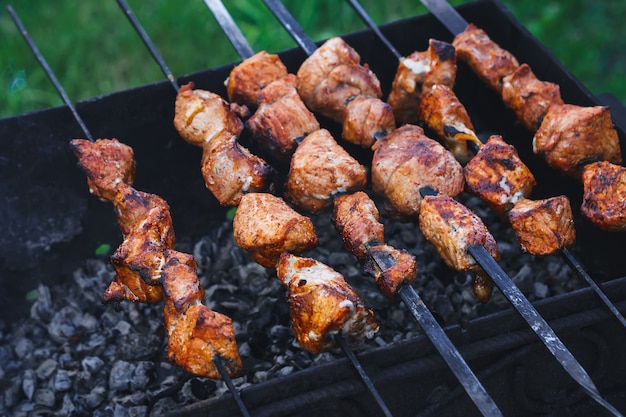 Churrasco de carne de porco é preparado no espeto na grelha