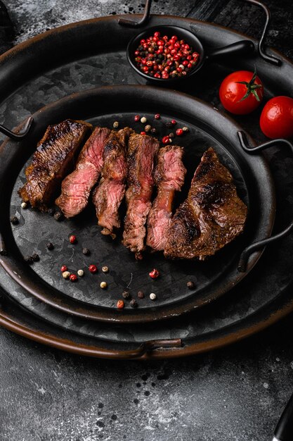 Churrasco de carne grelhada fatiada Bife de contrafilé sobre fundo de mesa de pedra preta escura