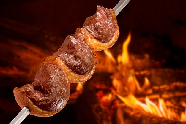 Churrasco de picanha assada no espeto na brasa amplamente consumida em todo  o brasil