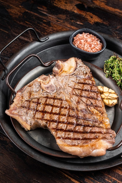 Churrasco grelhado Tbone ou Porterhouse carne bovina Bife em uma bandeja de aço com ervas Fundo de madeira Vista superior