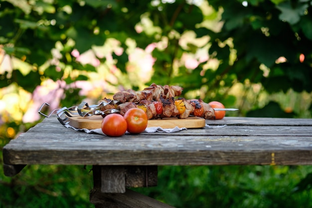 Churrasco recém-cozido em uma mesa de madeira. Almoço de verão na natureza. Saboroso prato de carne cozinhado no fogo.