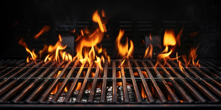 Foto churrasqueira portátil vazia e quente com fogo flamejante e carvão de brasa em fundo preto