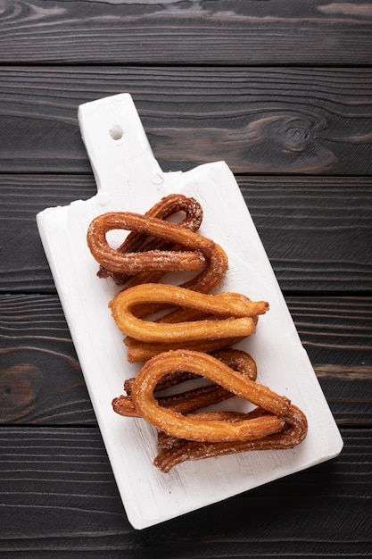 Foto churros caseiros em um fundo preto de madeira