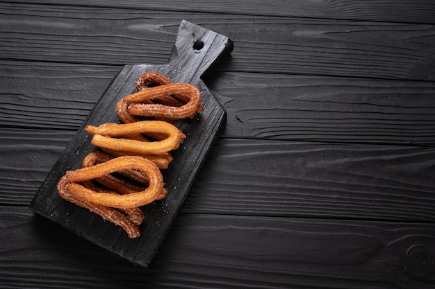 Churros caseros sobre un fondo negro de madera