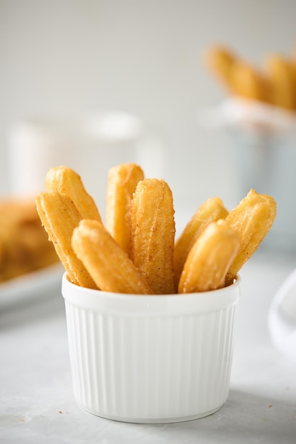 Churros com açúcar e canela sobre fundo leve Assamento caseiro de fast food tradicional de rua espanhola