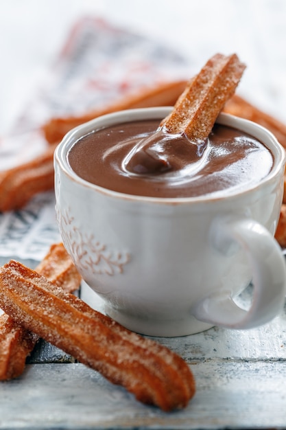 Churros de postre tradicional español con una taza de chocolate caliente