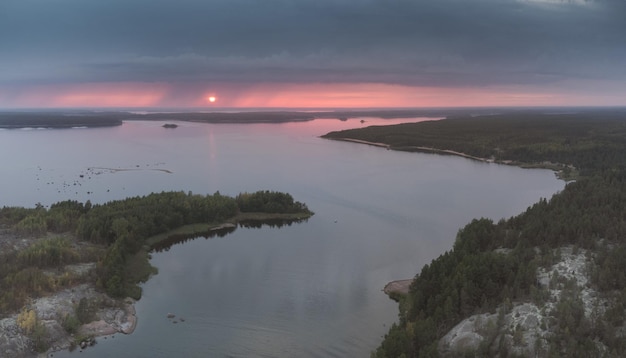 Chuva contra o céu do pôr do sol Panorama aéreo sobre o relevo nórdico do rio