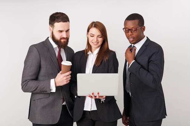 Chuva de ideias. grupo de empresários alegres olhando para o laptop juntos e sorrindo. conceito de projeto de sucesso