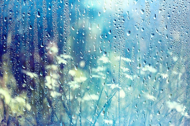 chuva de verão vidro molhado / paisagem de fundo abstrato em um dia chuvoso fora da janela fundo desfocado