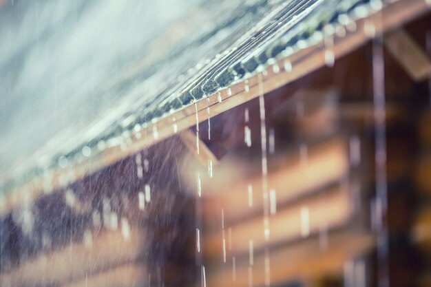 Foto chuva forte na tempestade de verão e gotas de chuva no telhado.