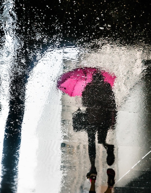 Chuva na cidade de nova york. reflexos de lajes molhadas. os pedestres se apressam em seus negócios. imagem borrada de movimento