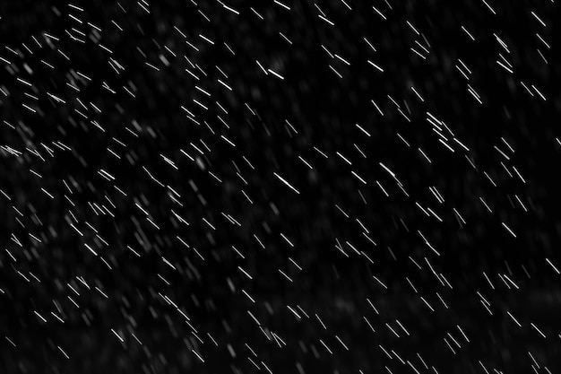 Chuva no preto. Salpicos abstratos de água em um fundo preto para modo de mesclagem de tela e retoque de fotos.