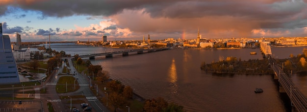 Chuva sobre riga, letônia ao pôr do sol. vista aérea da cidade velha de riga ao entardecer com nuvens de tempestade e chuva leve à luz do sol. tempestade mágica sobre a cidade. linda letônia.