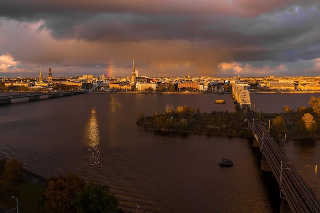 Chuva sobre riga, Letônia ao pôr do sol. Vista aérea da cidade velha de Riga ao entardecer com nuvens de tempestade e chuva leve à luz do sol. Tempestade mágica sobre a cidade. Linda Letônia.