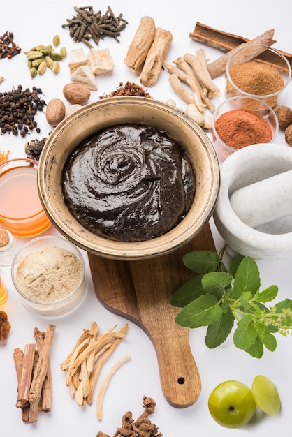 El Chyawanprash ayurvédico es un potente refuerzo de la inmunidad o un suplemento natural para la salud. Servido en un cuenco antiguo con ingredientes, sobre fondo cambiante, enfoque selectivo