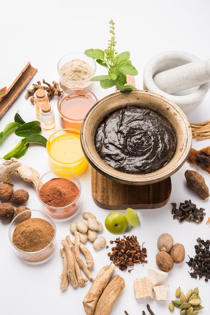 El Chyawanprash ayurvédico es un potente refuerzo de la inmunidad o un suplemento natural para la salud. Servido en un cuenco antiguo con ingredientes, sobre fondo cambiante, enfoque selectivo