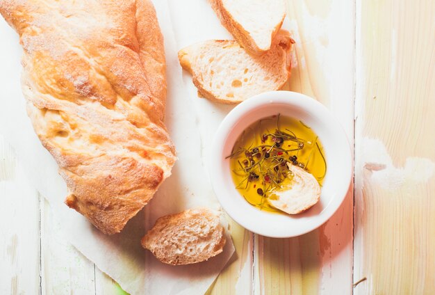 Ciabatta - italienisches Brot mit Olivenöl und Gewürzen über Holztisch