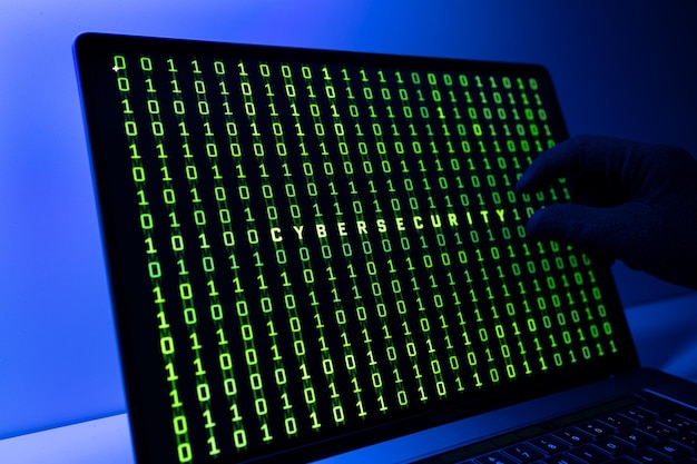 Ciber-Sicherheitskonzept Behandschuhte Hand Binärcode und Cybersicherheitswort auf dem Bildschirm des Laptops