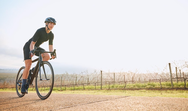 Ciclismo fitness e maquete com mulher no parque para treino de treino e saúde cardiovascular Exercício de viagem e liberdade com ciclista feminina andando de bicicleta na natureza para viagem de aventura e transporte