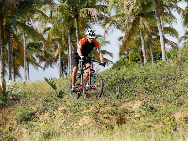 Ciclismo de montaña a través de un bosque tropical.