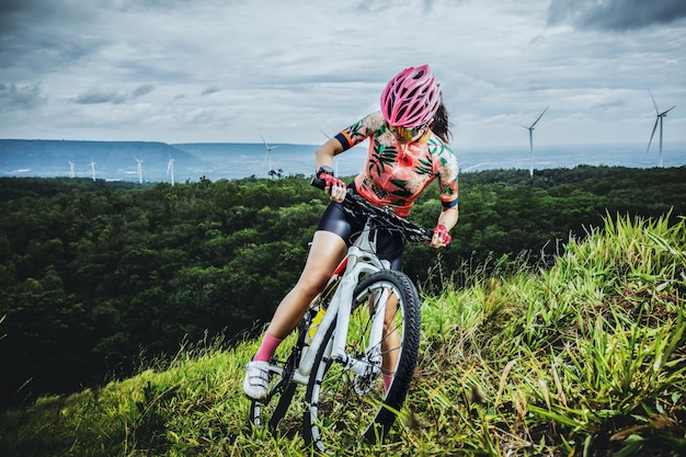 Foto ciclismo mulher andando de bicicleta de montanha no topo da montanha