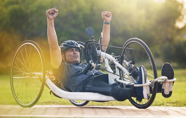 Ciclismo vencedor e homem feliz com treinamento de competição de deficiência com sucesso e campeão de exercícios na bicicleta Treino de felicidade e pessoa de celebração na bicicleta reclinada e vencedor da corrida