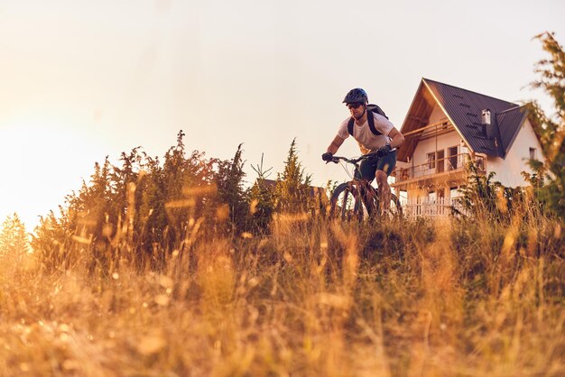 Un ciclista anda en bicicleta por caminos forestales al atardecer