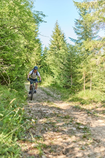 Un ciclista anda en bicicleta por caminos forestales extremos y peligrosos. Enfoque selectivo. foto de alta calidad