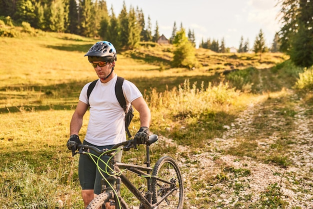 Un ciclista anda en bicicleta a su lado por los caminos del bosque