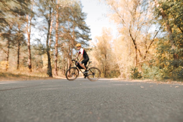 Ciclista anda pela cidade na floresta de outono