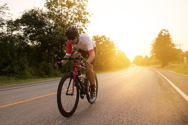 Ciclista asiático bebiendo agua después del concepto de salud y deporte ciclista