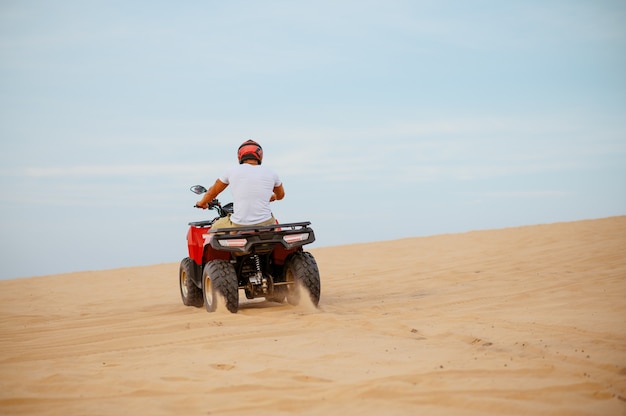 Un ciclista de atv corriendo en el desierto.