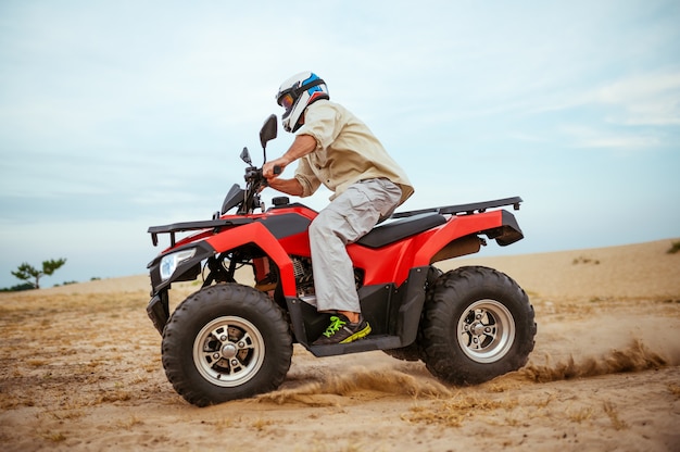 Un ciclista de atv corriendo en el desierto.