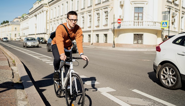 Un ciclista va en bicicleta al trabajo en la ciudad El transporte ecológico es moderno
