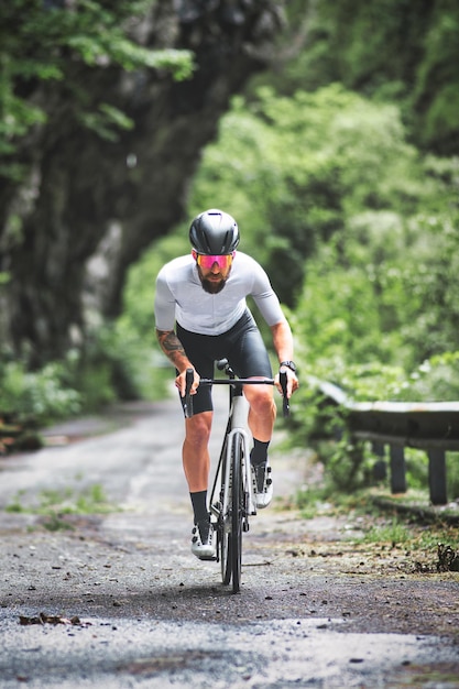 Un ciclista en una bicicleta de carreras en una carretera de montaña