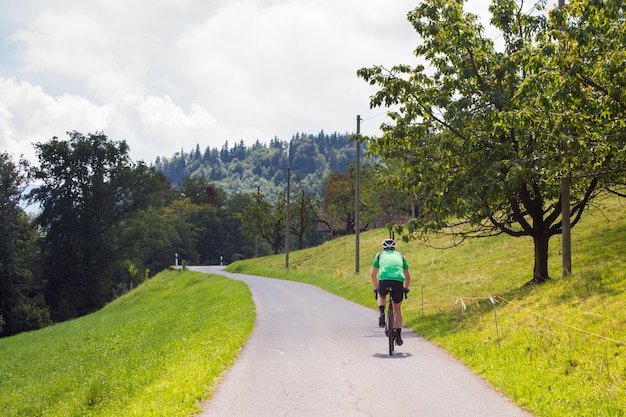 Ciclista en bicicleta por una carretera de asfalto de montaña