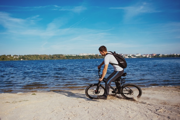 Ciclista en bicicleta en la playa